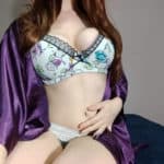 Sara wearing a purple robe, panties, and white bra with long curly hair